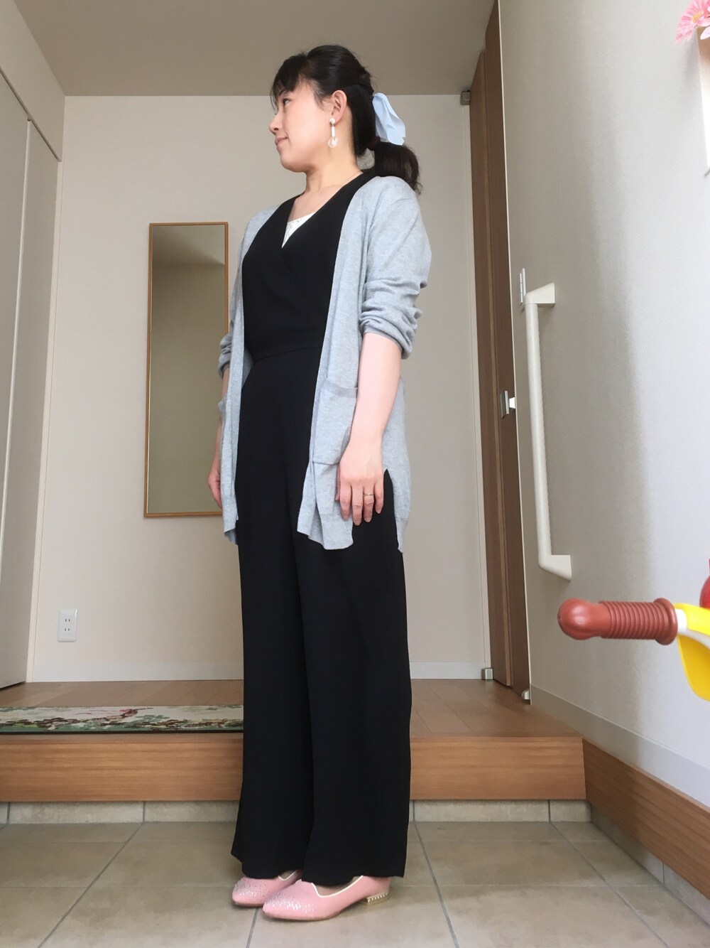 ブラック系のオールインワン・サロペット、グレー系のカーディガン/ボレロ、ピンク系のパンプスを着用したレディースの春コーディネートの1枚目の写真