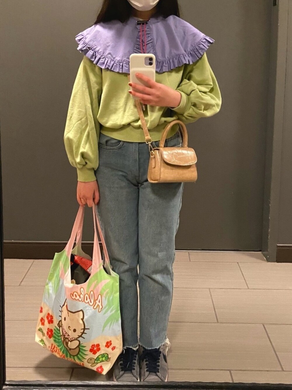 グリーン系のスウェット、ブルー系のデニムパンツ、ブルー系のスニーカーを着用したレディースの秋コーディネートの1枚目の写真