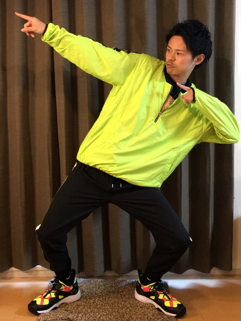 ブラック系のTシャツ/カットソー、イエロー系のスニーカー、イエロー系のナイロンジャケットを着用したメンズの春コーディネートの1枚目の写真