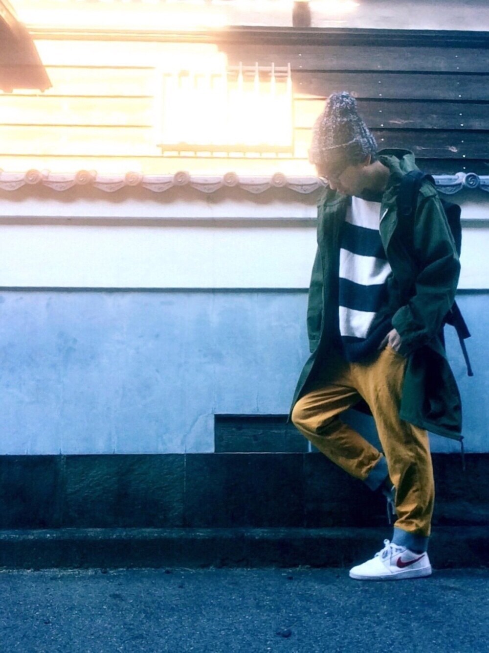 グリーン系のミリタリージャケット、イエロー系のその他パンツ、ホワイト系のニット/セーターを着用したメンズの冬コーディネートの1枚目の写真