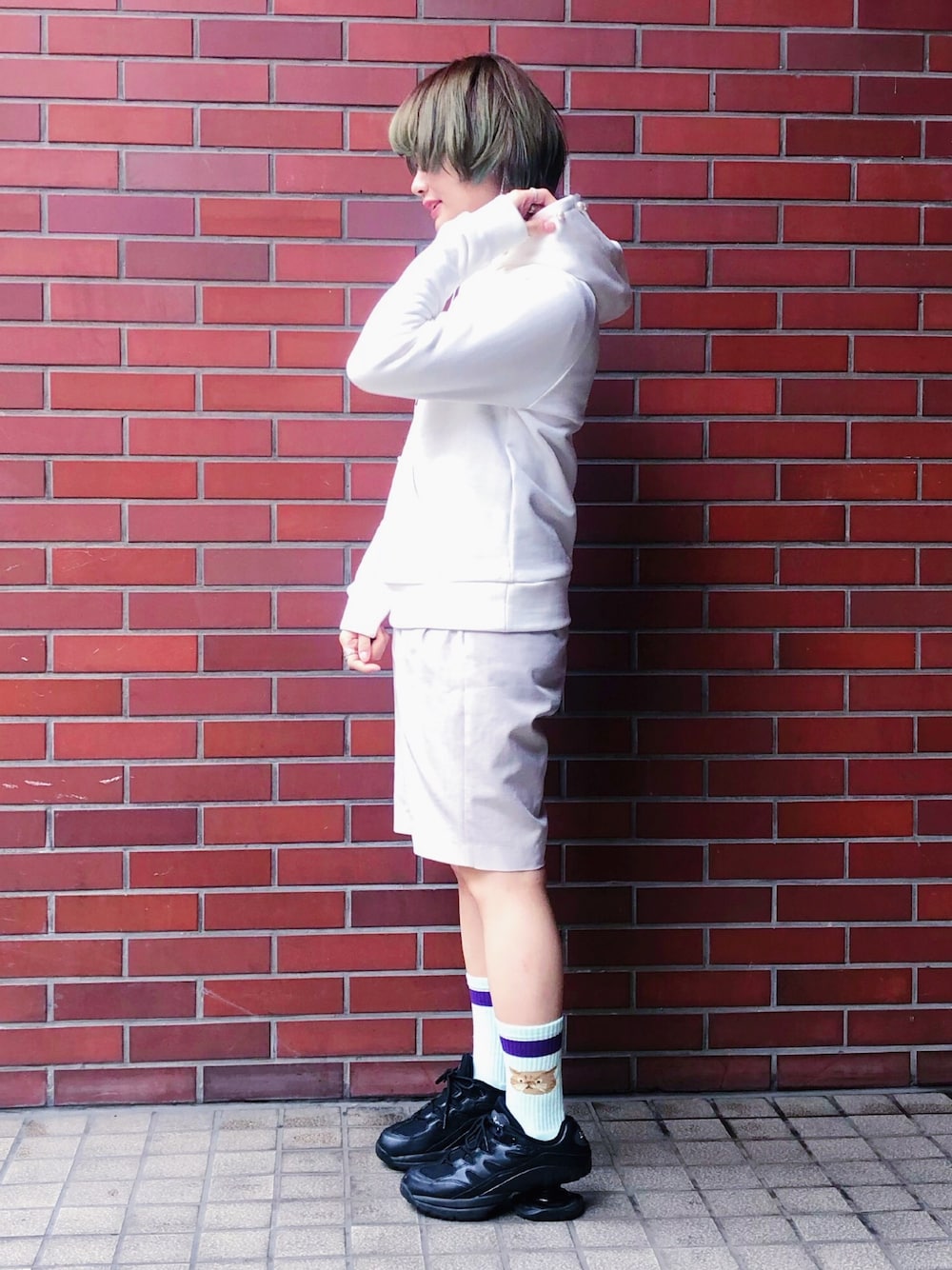 ホワイト系のパーカー、ホワイト系のパンツ、ブラック系のスニーカーを着用したレディースの春コーディネートの1枚目の写真