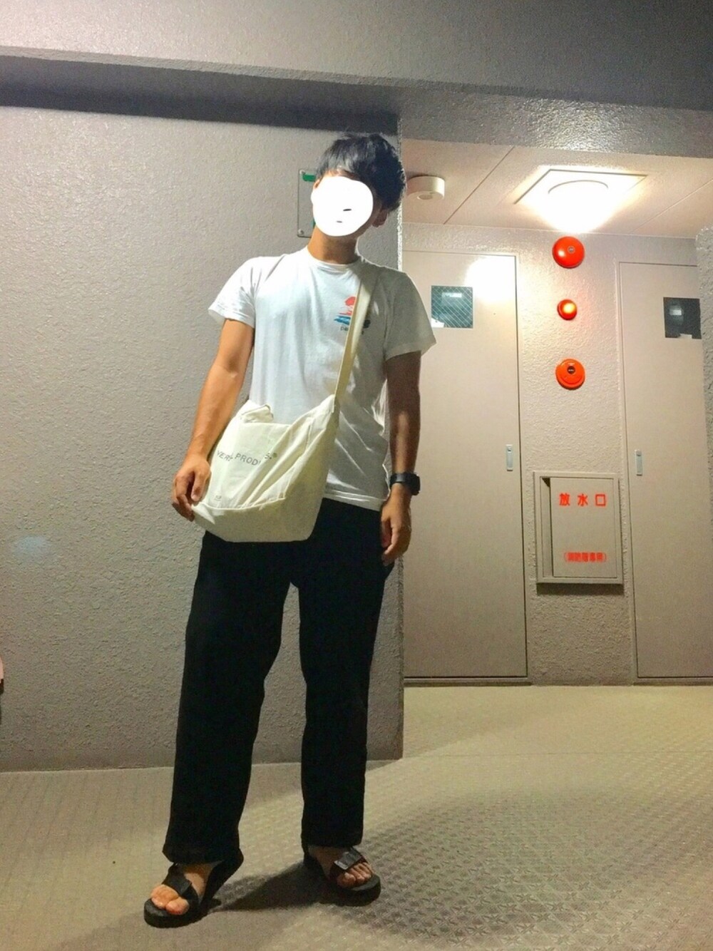 ブラック系のチノパンツ、ブラック系のサンダル、ホワイト系のトートバッグを着用したメンズの秋コーディネートの1枚目の写真