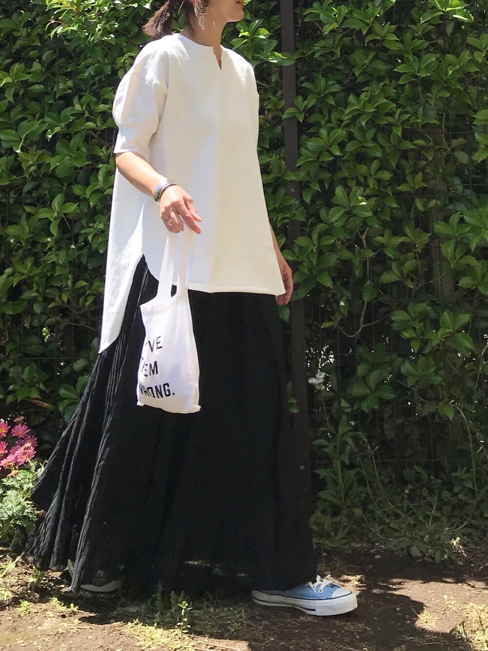 ホワイト系のTシャツ/カットソー、ブラック系のスカート、その他のバングル/リストバンドを着用したレディースの春コーディネートの1枚目の写真