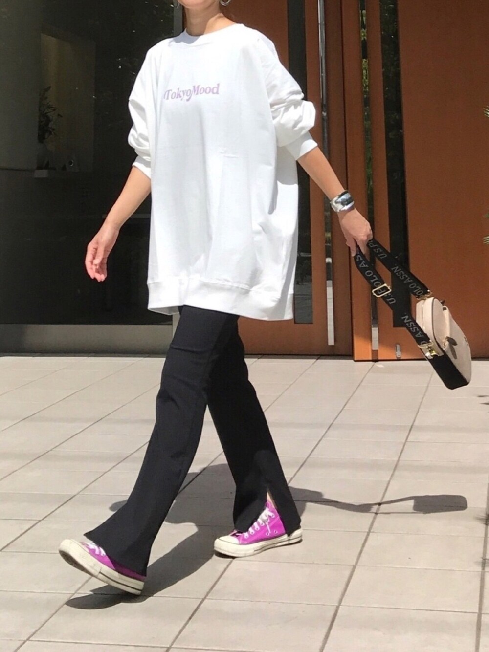ホワイト系のTシャツ/カットソー、ベージュ系のショルダーバッグ、ブラック系のパンツを着用したレディースの秋コーディネートの1枚目の写真