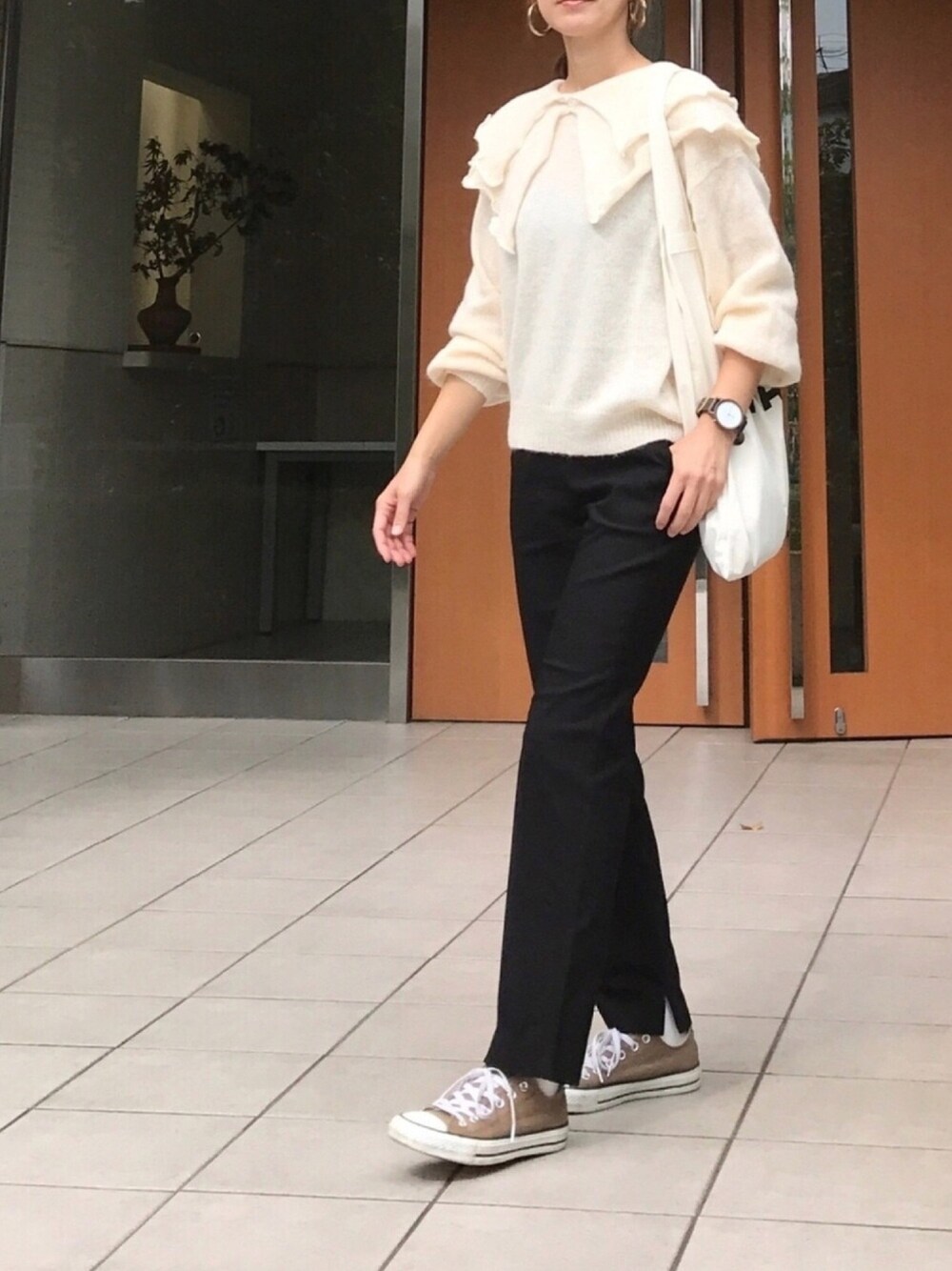 ベージュ系のニット/セーター、ブラック系のその他パンツ、ブラウン系のスニーカーを着用したレディースの秋コーディネートの1枚目の写真