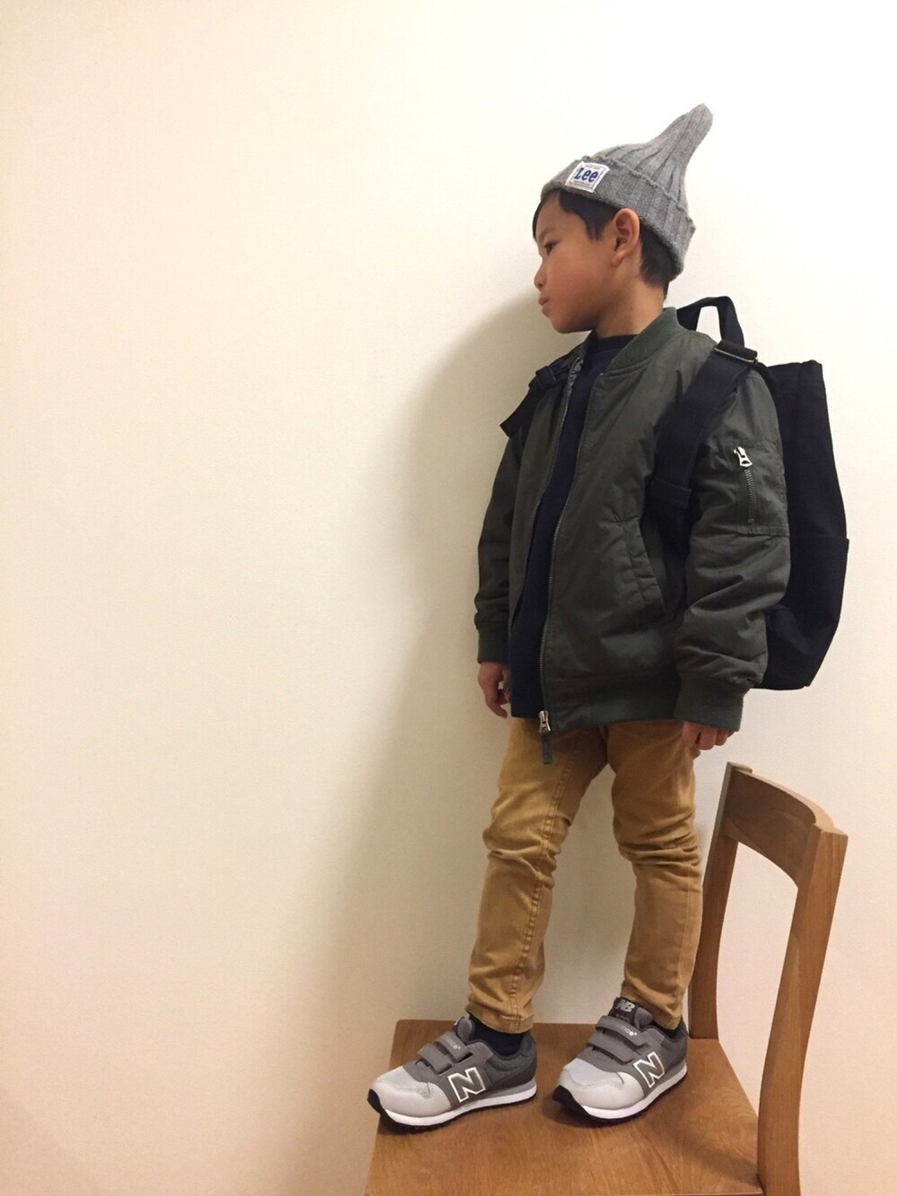 グリーン系のジャケット/アウター、ベージュ系のチノパンツを着用したキッズの冬コーディネートの1枚目の写真