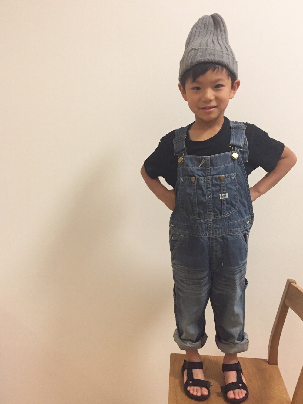ブルー系のサロペット/オーバーオール、ブラック系のサンダル、グレー系のニットキャップ/ビーニーを着用したキッズの夏コーディネートの1枚目の写真