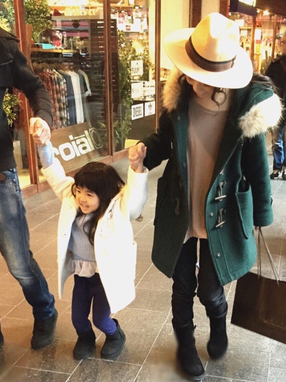 グリーン系のダッフルコート、ホワイト系のダッフルコート、ブラック系のブーツを着用したレディースの冬コーディネートの1枚目の写真