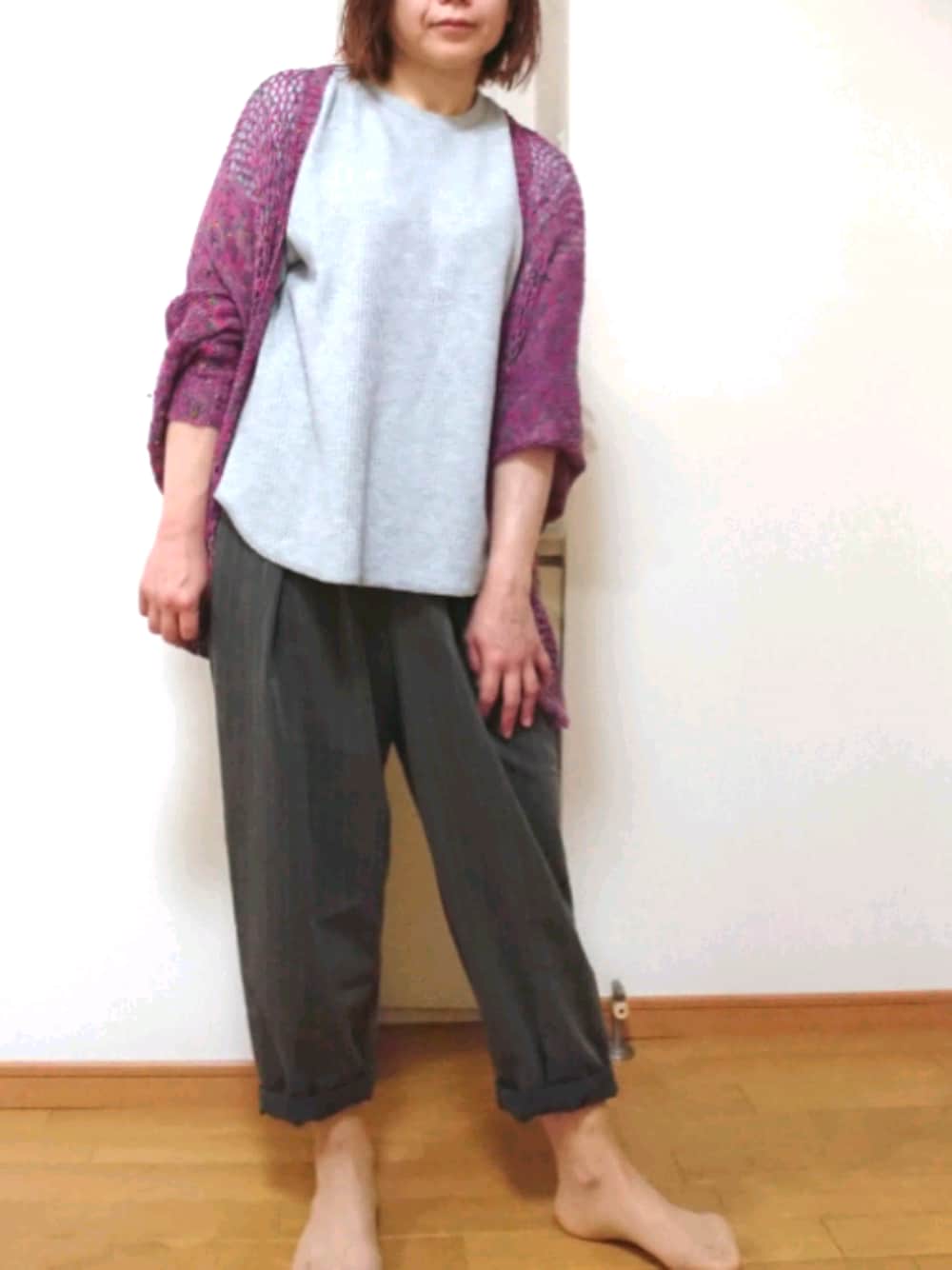 グレー系のスラックス、グレー系のTシャツ/カットソー、ピンク系のカーディガン/ボレロを着用したレディースの春コーディネートの1枚目の写真