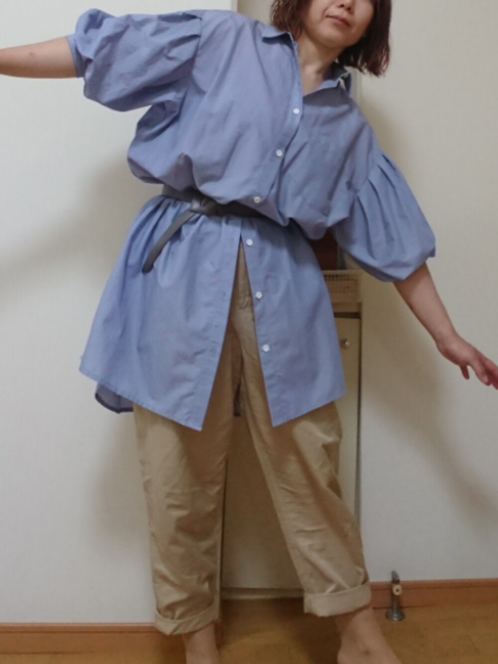 ベージュ系のスラックス、ブルー系のシャツワンピース、グレー系のベルトを着用したレディースの春コーディネートの1枚目の写真