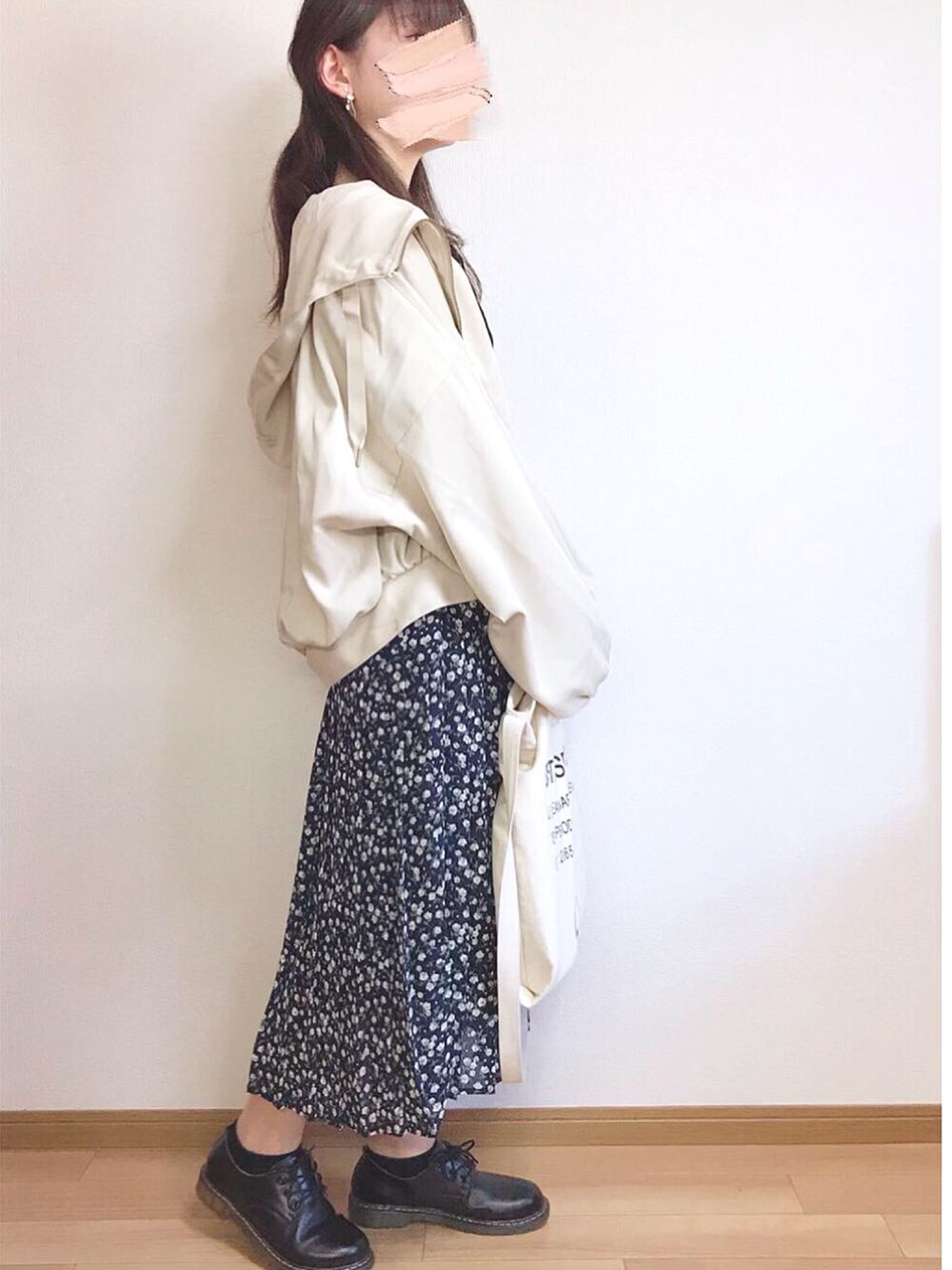 ベージュ系のブルゾン、ブルー系のスカート、ブラック系のTシャツ/カットソーを着用したレディースの冬コーディネートの1枚目の写真