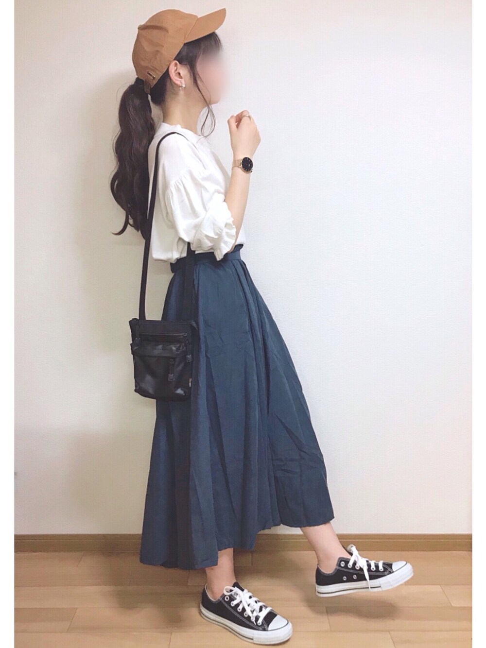 ブルー系のスカート、ホワイト系のニット/セーター、ブラック系のスニーカーを着用したレディースの秋コーディネートの1枚目の写真