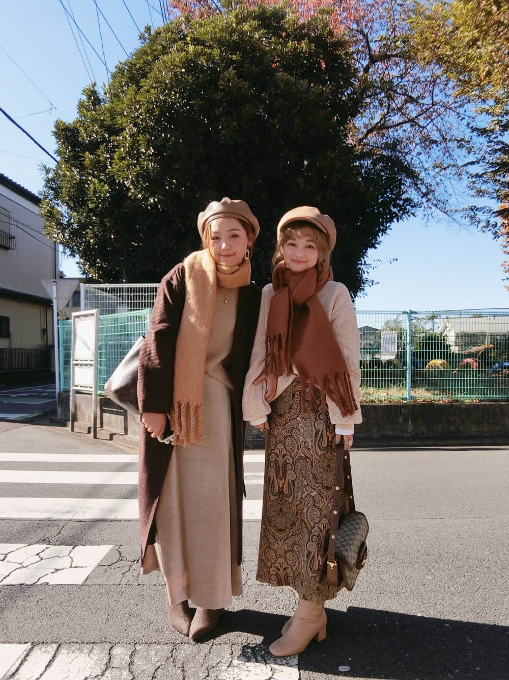 グリーン系のスカートを着用したレディースの秋コーディネートの1枚目の写真