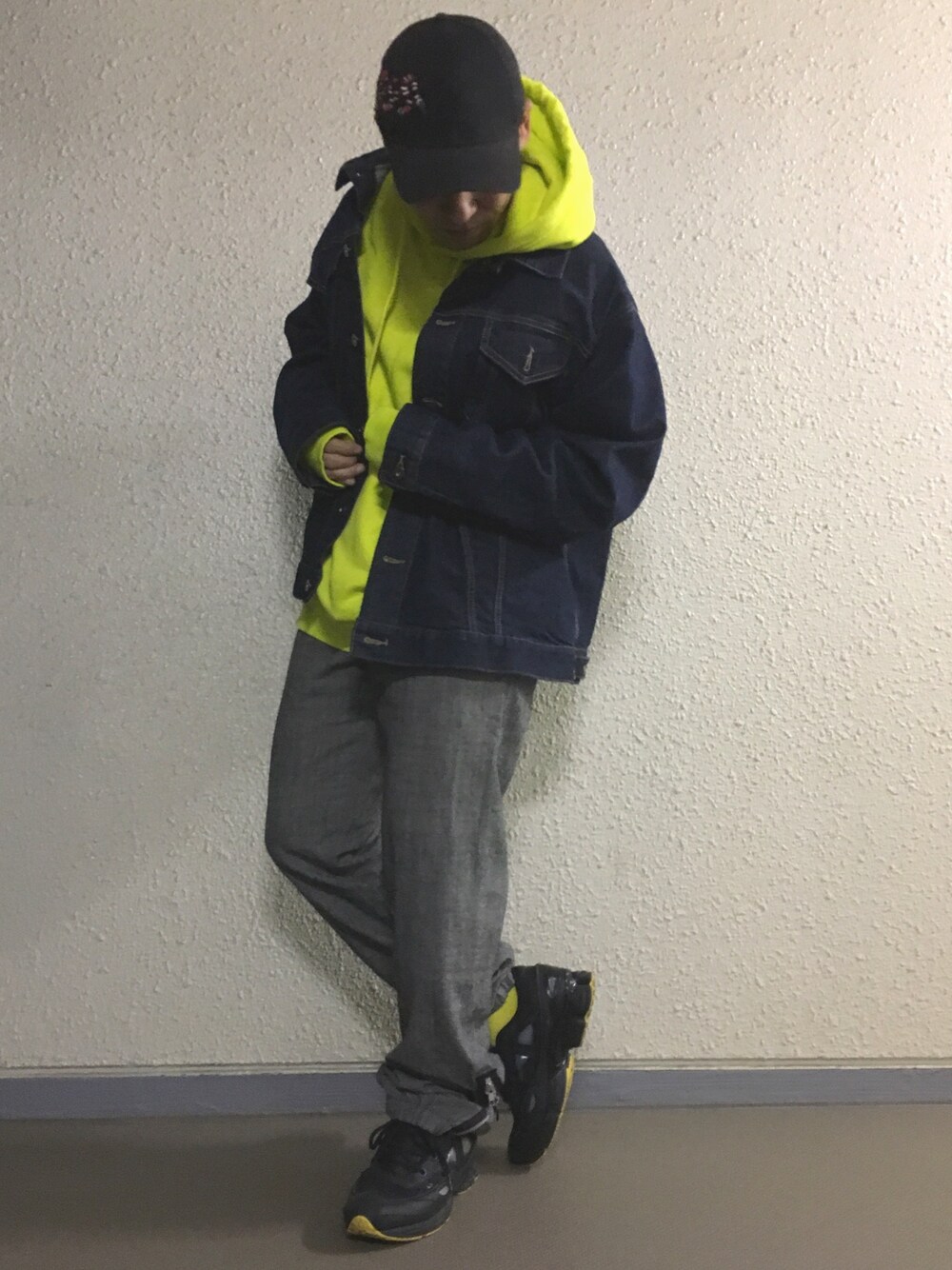 イエロー系のパーカー、ブルー系のデニムジャケット、グレー系のパンツを着用したメンズの春コーディネートの1枚目の写真