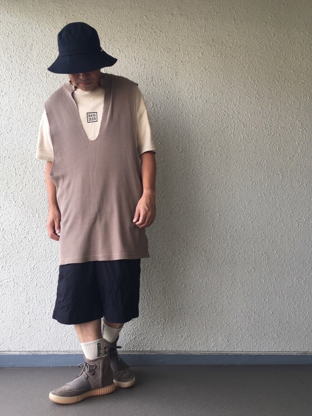 ブラウン系のタンクトップ、ベージュ系のTシャツ/カットソー、ブラック系のパンツを着用したメンズの秋コーディネートの1枚目の写真