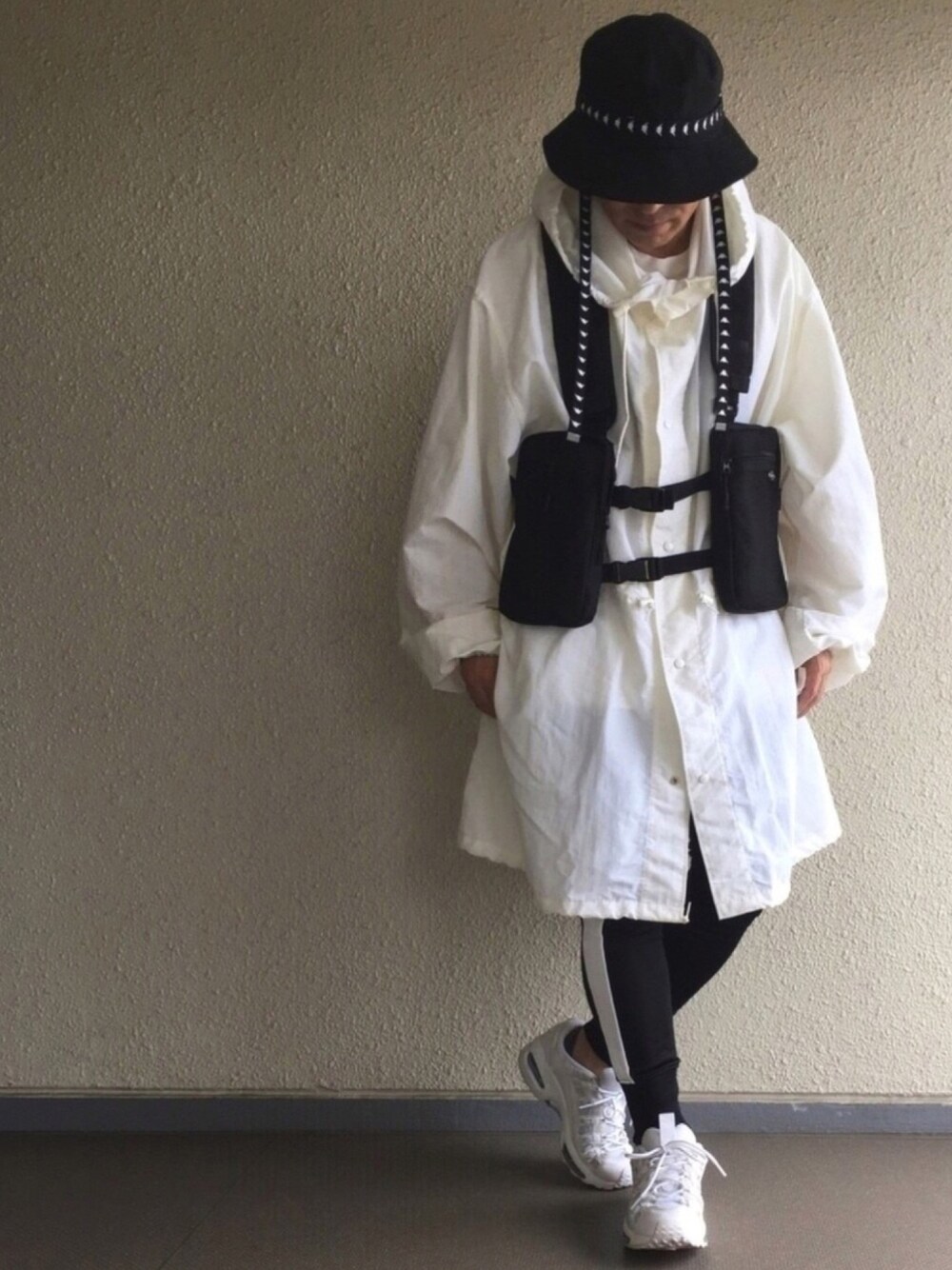 ブラック系のボディバッグ/ウエストポーチ、ブラック系のパンツ、ホワイト系のスニーカーを着用したメンズの春コーディネートの1枚目の写真