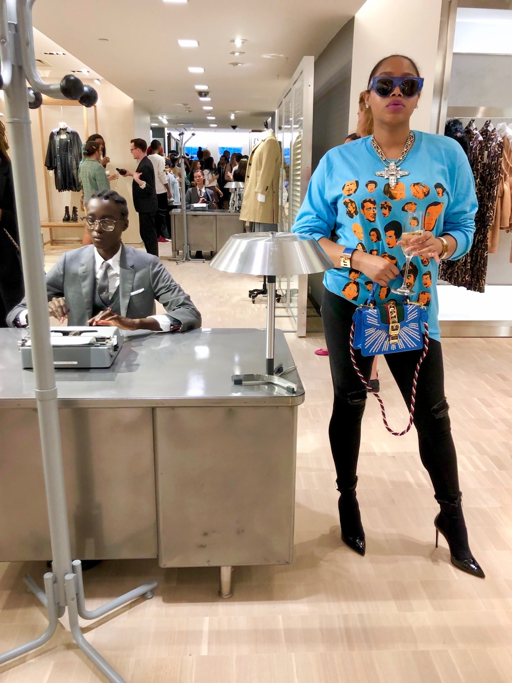 ブルー系のショルダーバッグ、ブラック系のブーツ、ブルー系のTシャツ/カットソーを着用したレディースの秋コーディネートの1枚目の写真