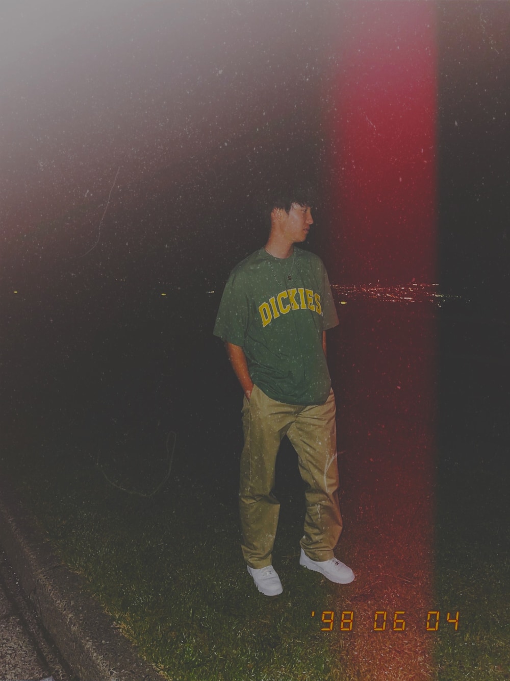 グリーン系のTシャツ/カットソー、ベージュ系のチノパンツ、ホワイト系のスニーカーを着用したメンズの夏コーディネートの1枚目の写真