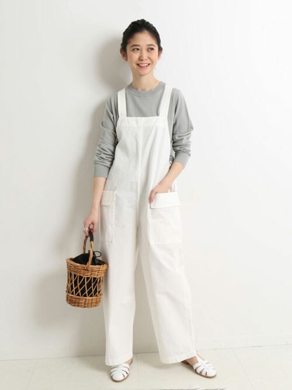 グレー系のニット/セーター、ホワイト系のサンダルを着用したレディースの冬コーディネートの1枚目の写真