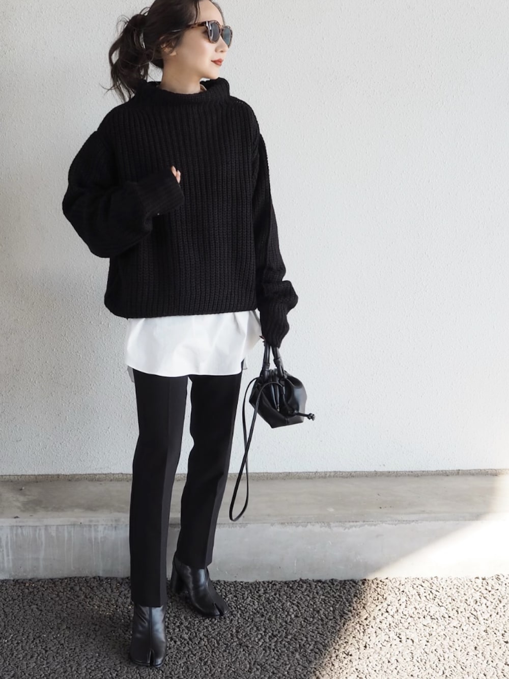 ブラック系のニット/セーター、ホワイト系のシャツ/ブラウスを着用したレディースの秋コーディネートの1枚目の写真