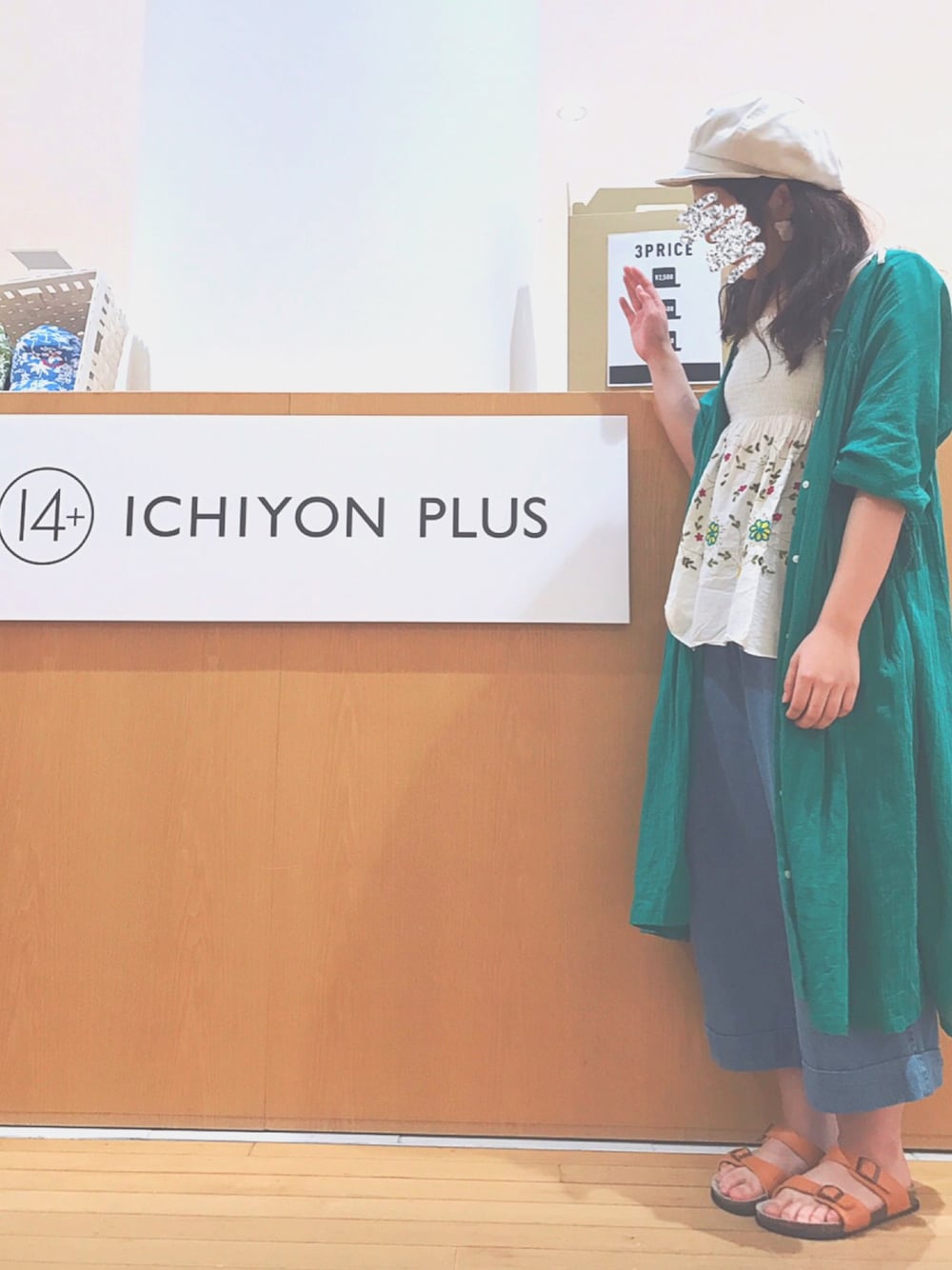 グリーン系のワンピース、ブルー系のデニムパンツ、ホワイト系のキャスケットを着用したレディースの夏コーディネートの1枚目の写真