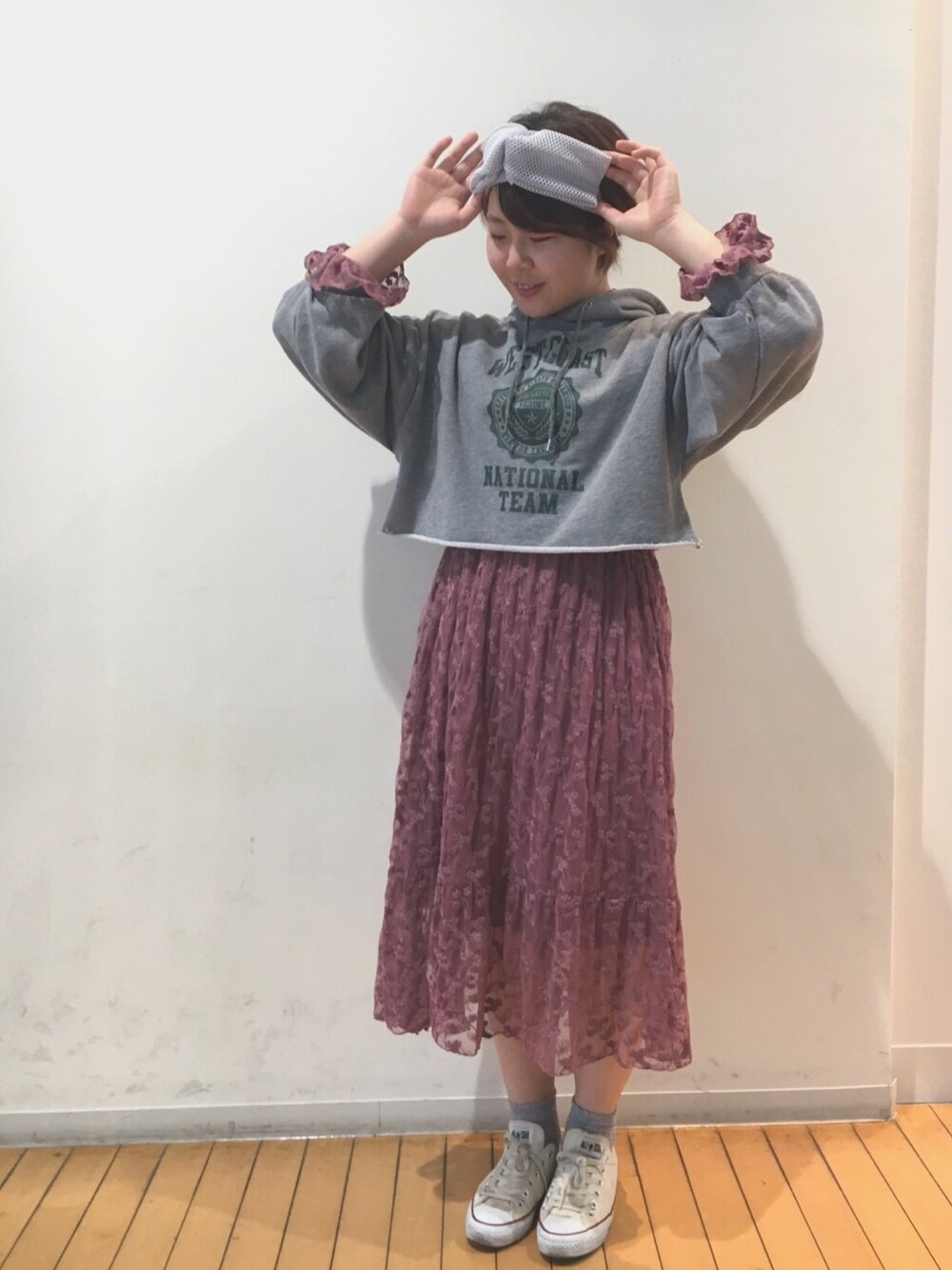 ピンク系のワンピース、ベージュ系のスニーカー、ホワイト系のヘアバンドを着用したレディースの春コーディネートの1枚目の写真
