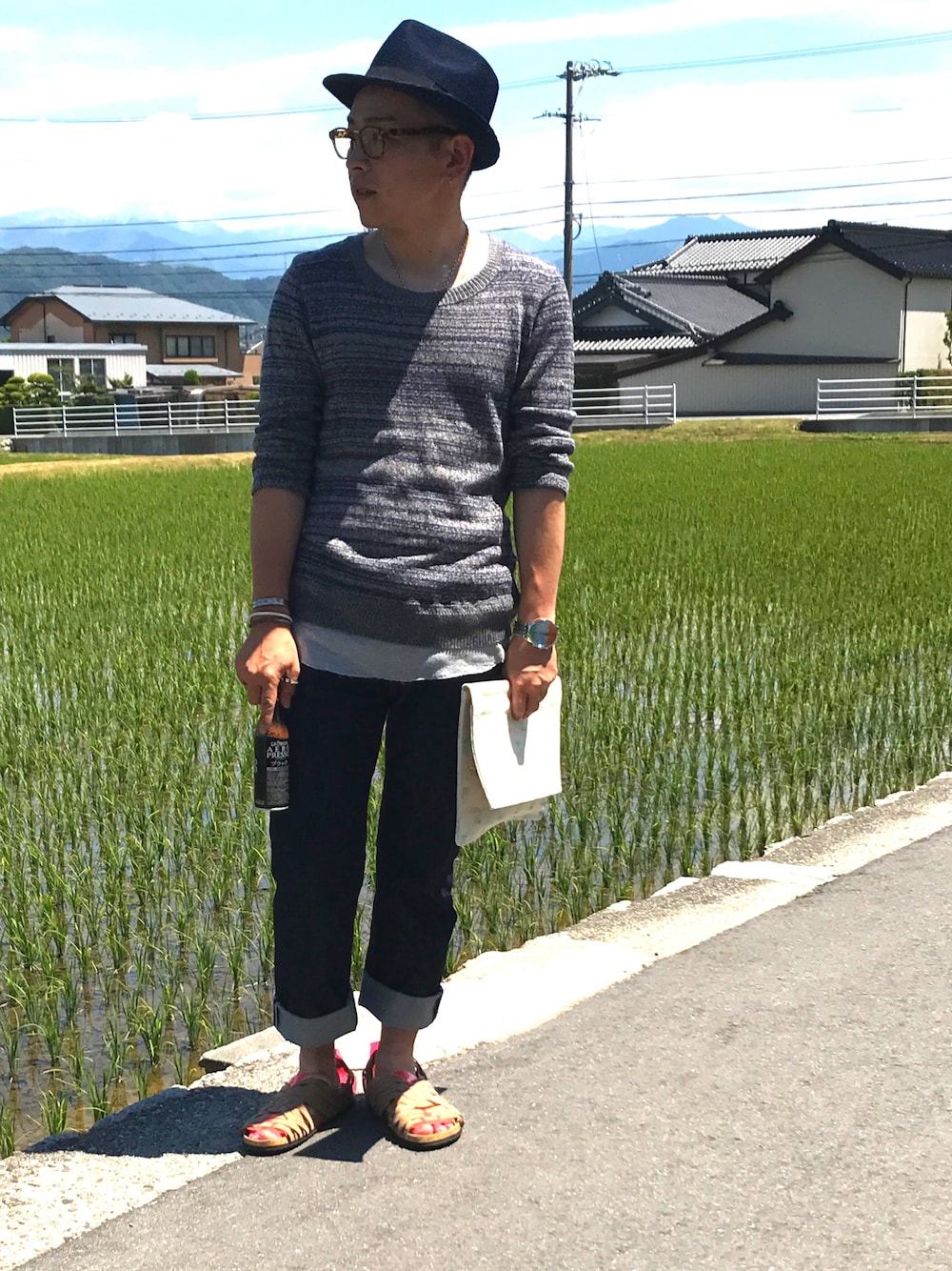 ブルー系のニット/セーター、ブルー系のデニムパンツ、ブラウン系のシューズを着用したメンズの夏コーディネートの1枚目の写真