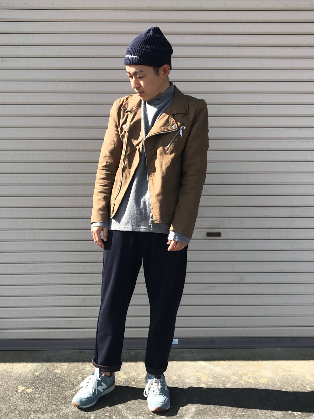 グレー系のトップス、ベージュ系のライダースジャケット、ブルー系のその他パンツを着用したメンズの秋コーディネートの1枚目の写真