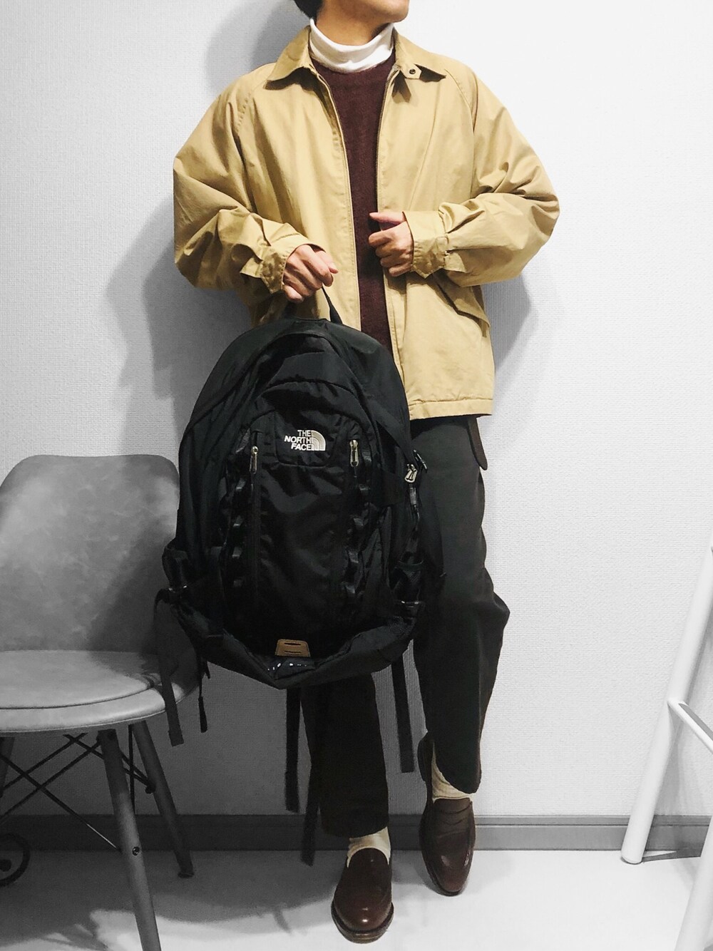 ベージュ系のブルゾン、ホワイト系のトップス、レッド系のニット/セーターを着用したメンズの冬コーディネートの1枚目の写真