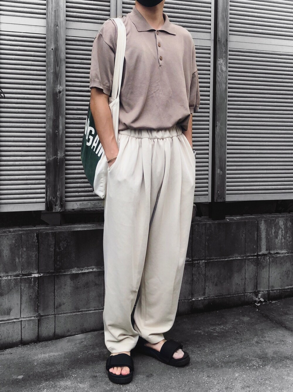 ベージュ系のポロシャツ、ベージュ系のスウェットパンツ、ブラック系のサンダルを着用したメンズの秋コーディネートの1枚目の写真