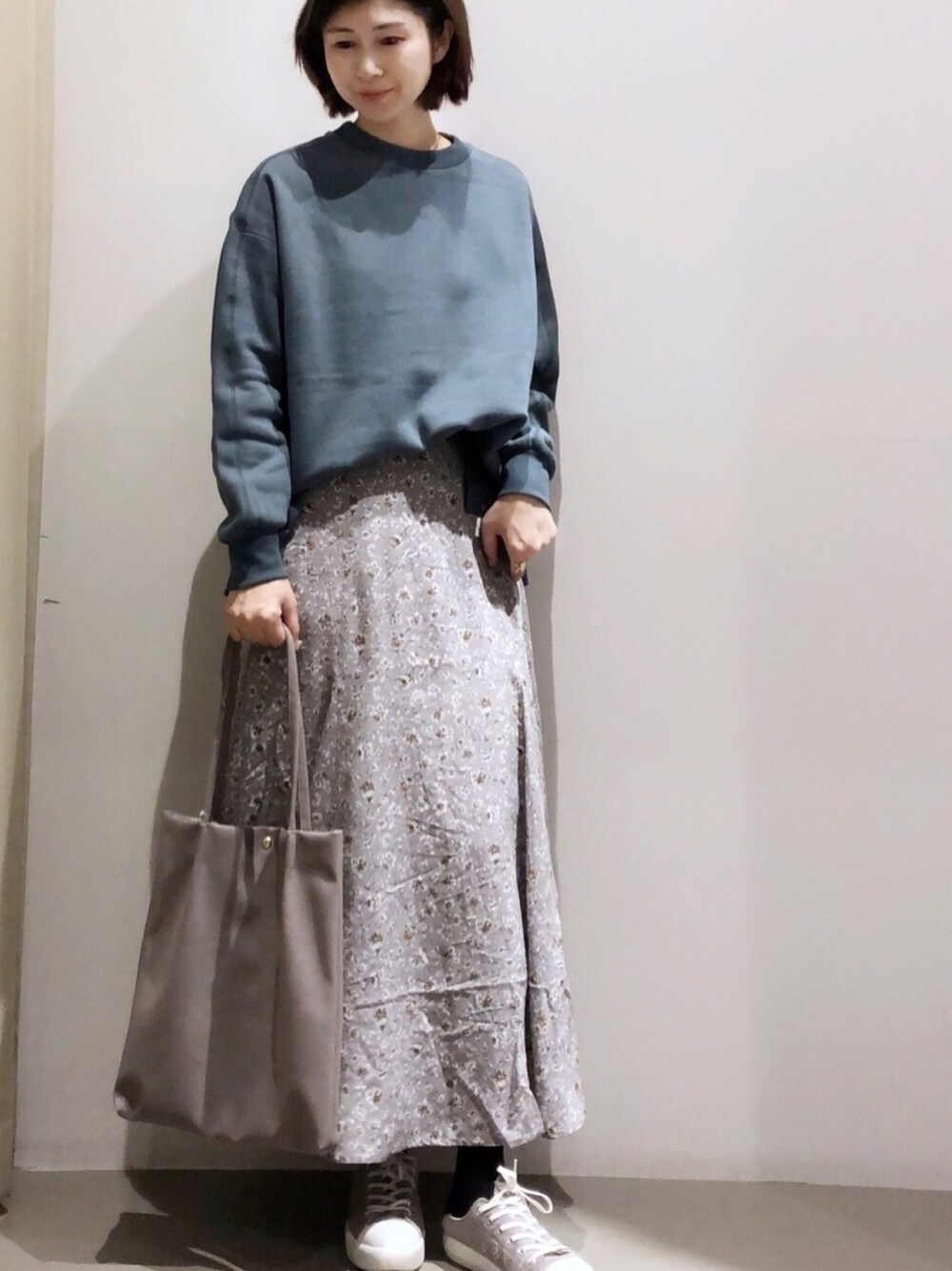 ブルー系のTシャツ/カットソー、グレー系のスカート、グレー系のトートバッグを着用したレディースの秋コーディネートの1枚目の写真