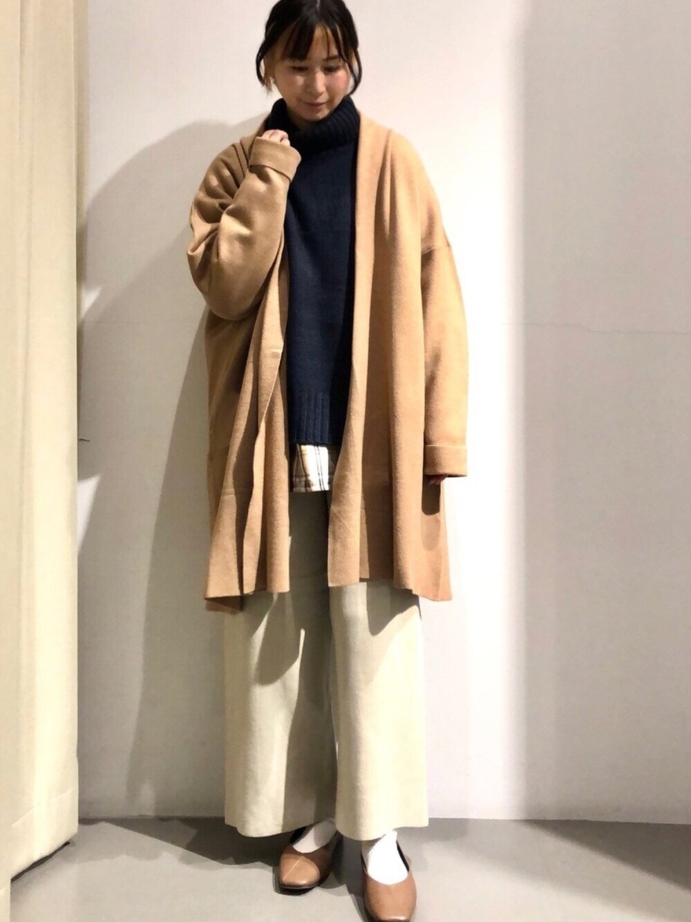 ブルー系のニット/セーター、イエロー系のカーディガン/ボレロ、ベージュ系のシャツ/ブラウスを着用したレディースの冬コーディネートの1枚目の写真
