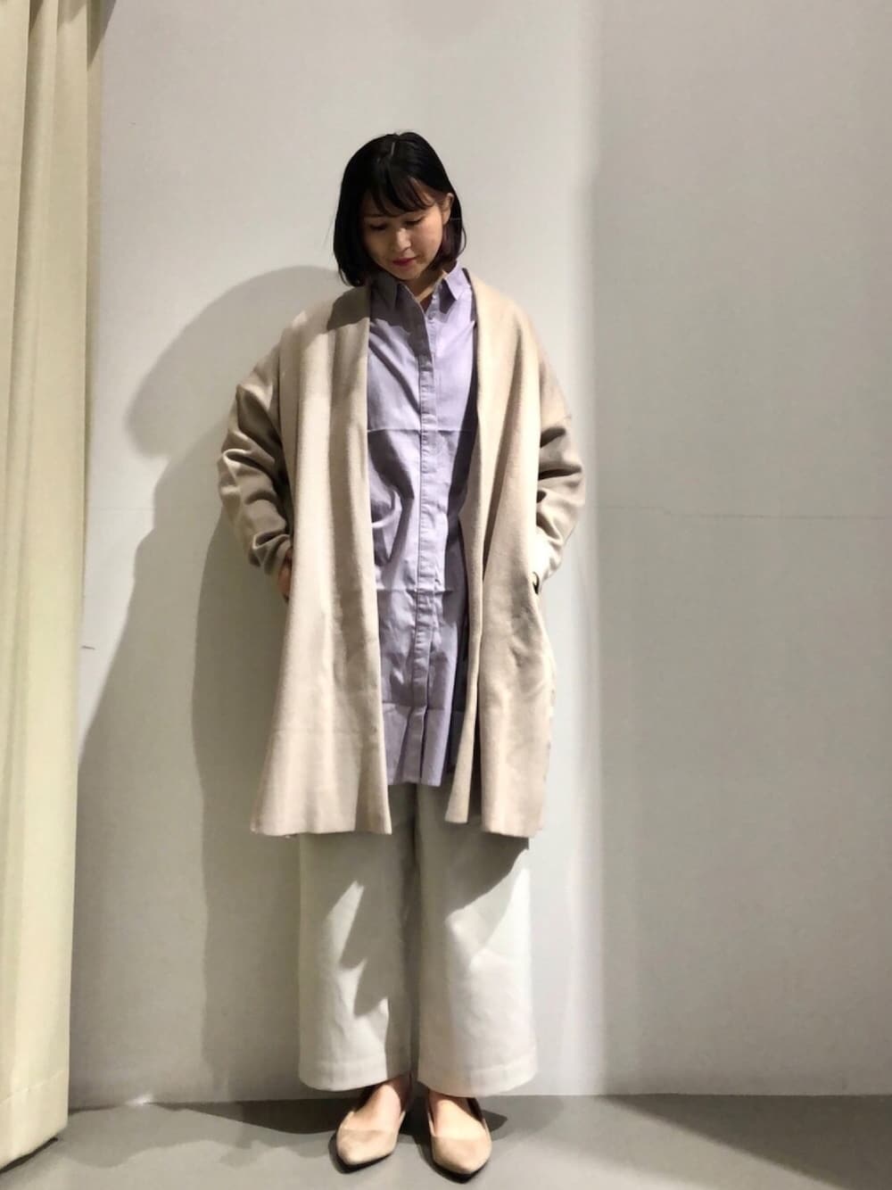 パープル系のシャツ/ブラウス、グレー系のカーディガン/ボレロ、ベージュ系のパンツを着用したレディースの冬コーディネートの1枚目の写真