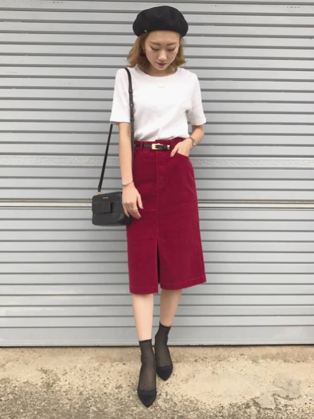 レッド系のスカート、ブラック系のパンプス、ホワイト系のTシャツ/カットソーを着用したレディースの秋コーディネートの1枚目の写真