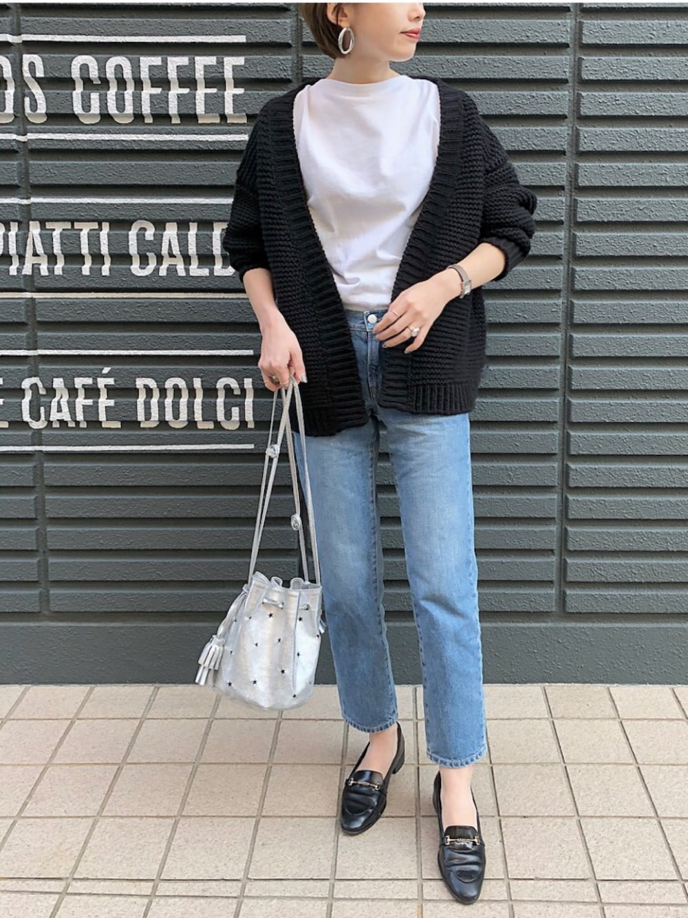 ブラック系のカーディガン/ボレロ、ブルー系のデニムパンツ、ブラック系のローファーを着用したレディースの秋コーディネートの1枚目の写真