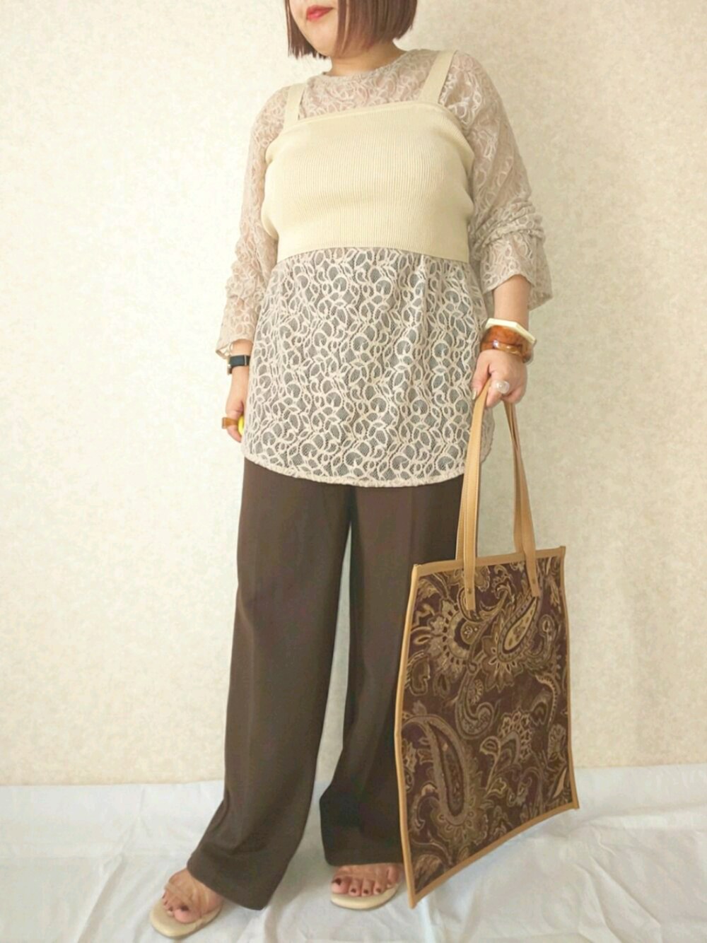 ベージュ系のシャツ/ブラウス、ベージュ系のトップス、ブラウン系のパンツを着用したレディースの秋コーディネートの1枚目の写真