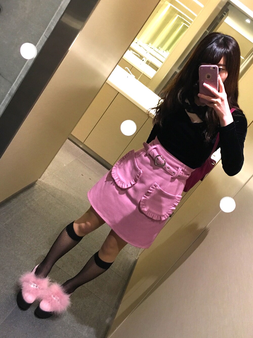 ピンク系のスカート、ピンク系のシューズ、ブラック系のトップスを着用したレディースの冬コーディネートの1枚目の写真