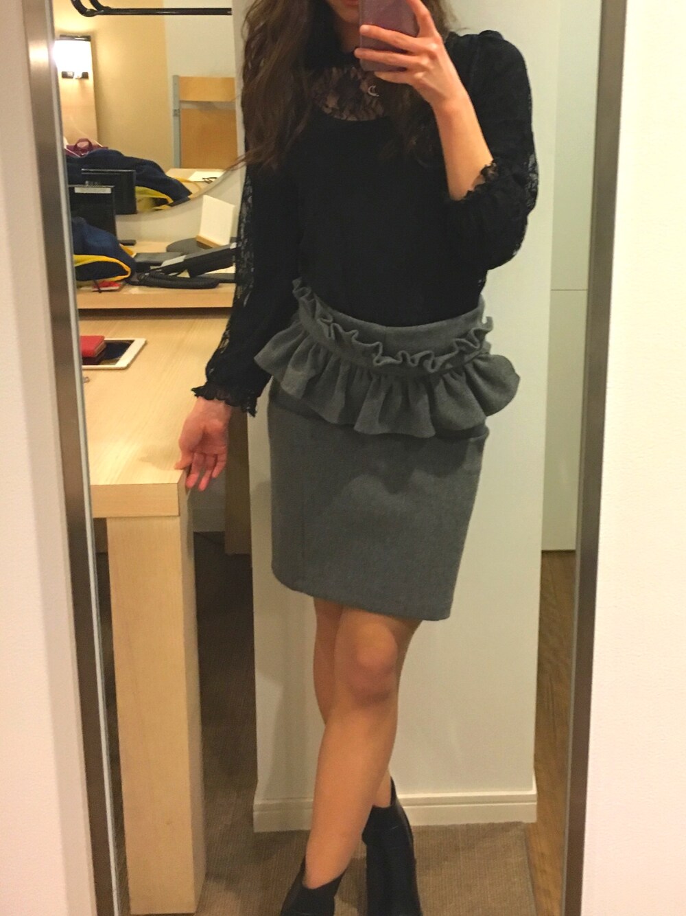 ブラック系のトップス、グレー系のスカート、ブラック系のシューズを着用したレディースの冬コーディネートの1枚目の写真