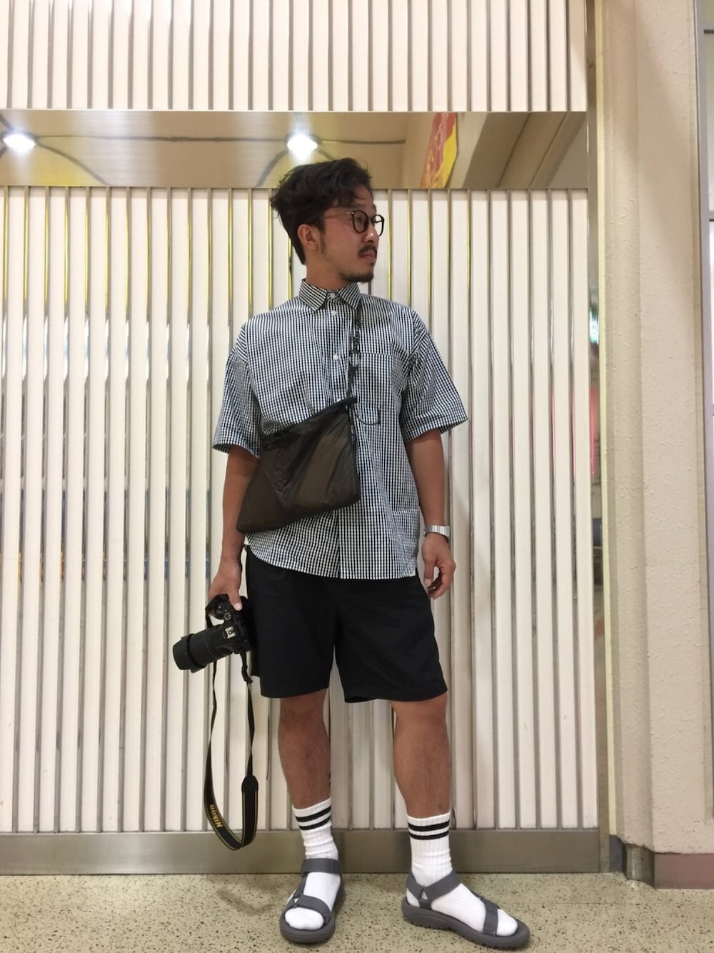 「夏、黒、ドロップショルダー、オトナカジュアル、アラフォー、ギンガムチェック、koe渋谷、teva、Teva×靴下、CASIO」｜「and wanderのand wander/アンドワンダー　SIL SACOCHE/シルサコッシュ　（ショルダーバッグ、ブラウン系）」を使った、bashibashiさん（メンズ・168cm）の夏コーディネートの1枚目の写真