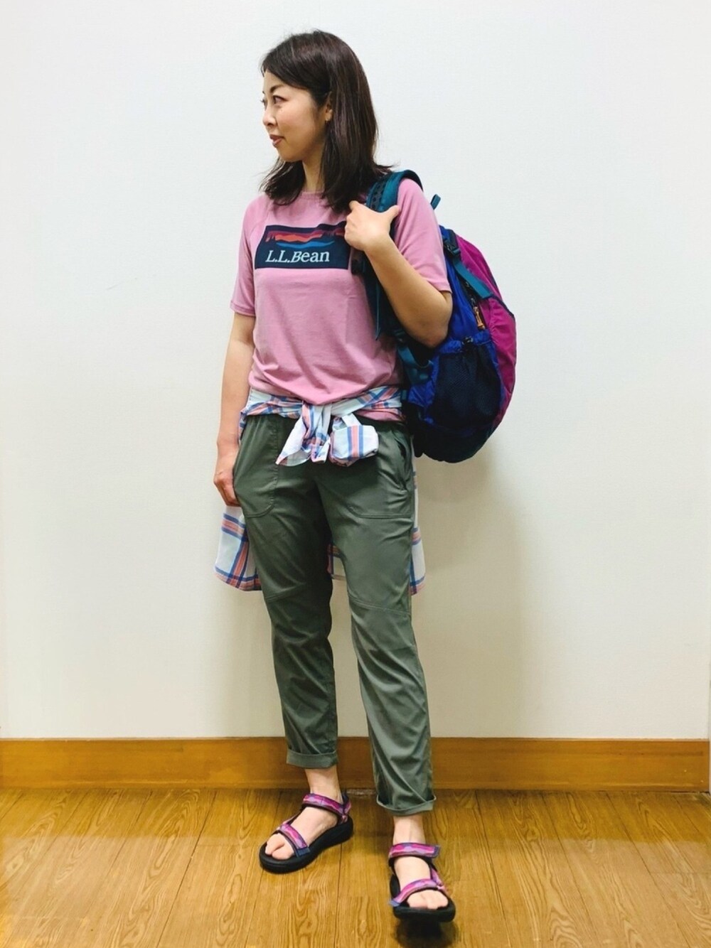 ピンク系のTシャツ/カットソー、ブルー系のバックパック/リュック、ホワイト系のシャツ/ブラウスを着用したレディースの春コーディネートの1枚目の写真