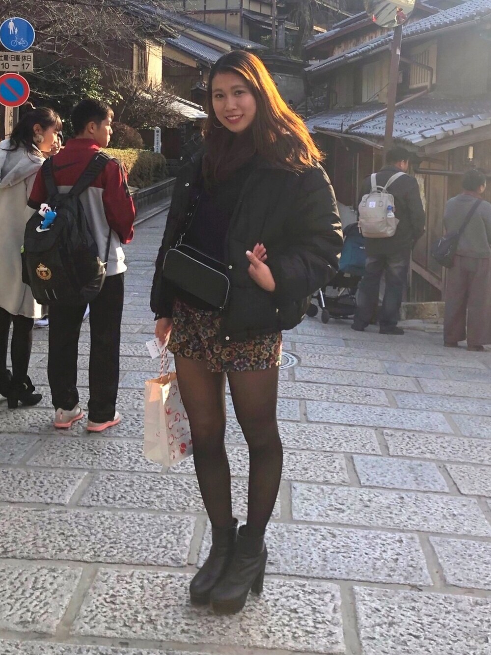 ブラック系のダウンジャケット/コート、ブラック系のニット/セーター、ブラック系のブーツを着用したレディースの冬コーディネートの1枚目の写真