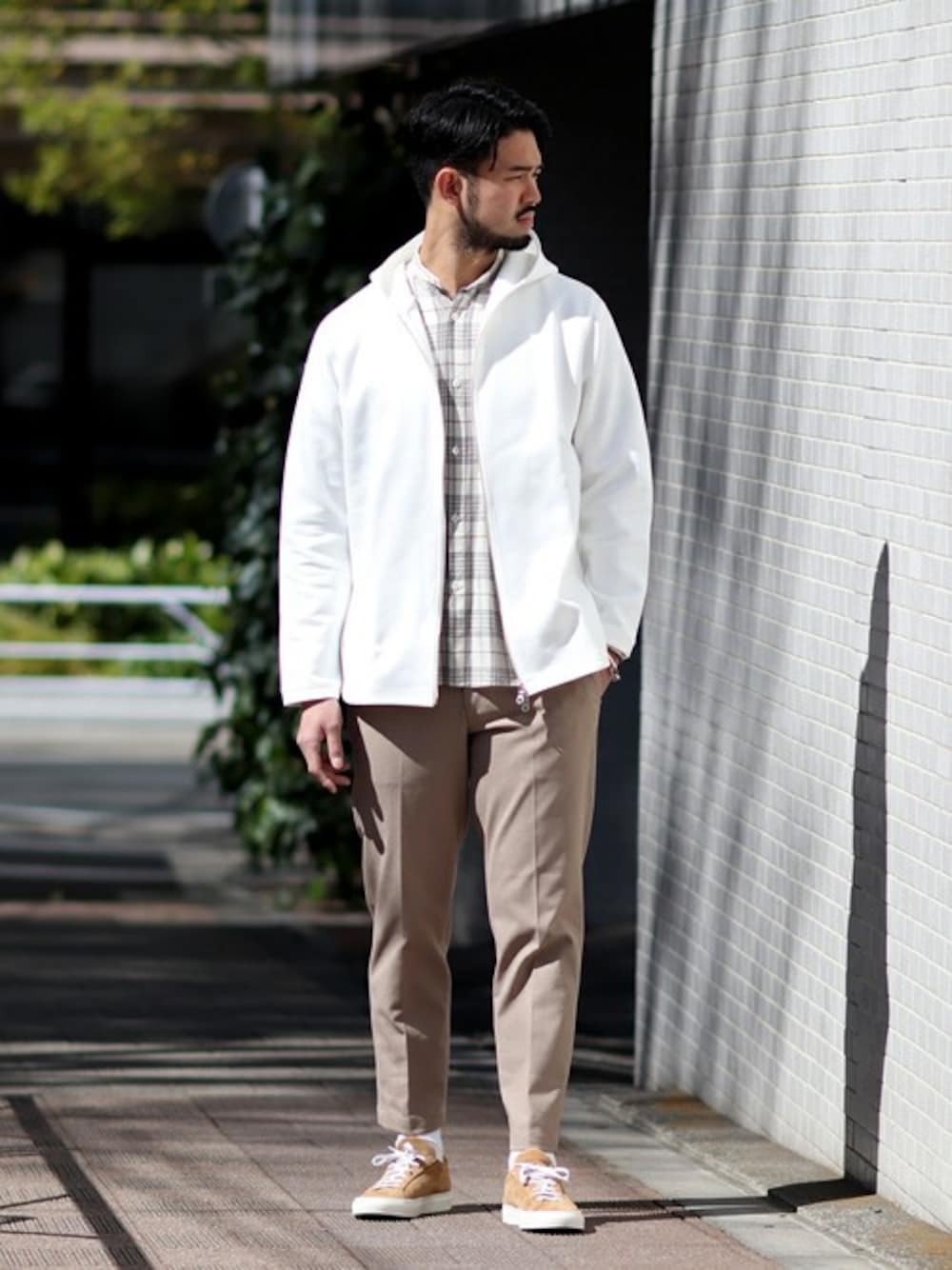 ホワイト系のパーカー、ベージュ系のその他パンツを着用したメンズの春コーディネートの1枚目の写真