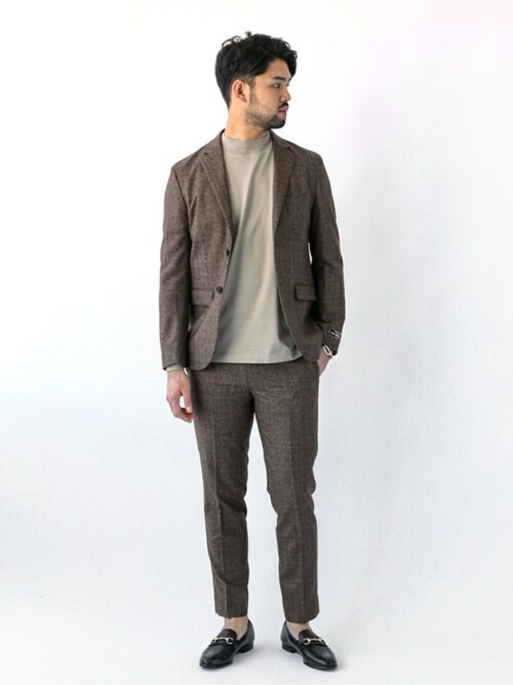 ブラウン系のテーラードジャケット、ブラウン系のその他パンツ、ベージュ系のTシャツ/カットソーを着用したメンズの秋コーディネートの1枚目の写真