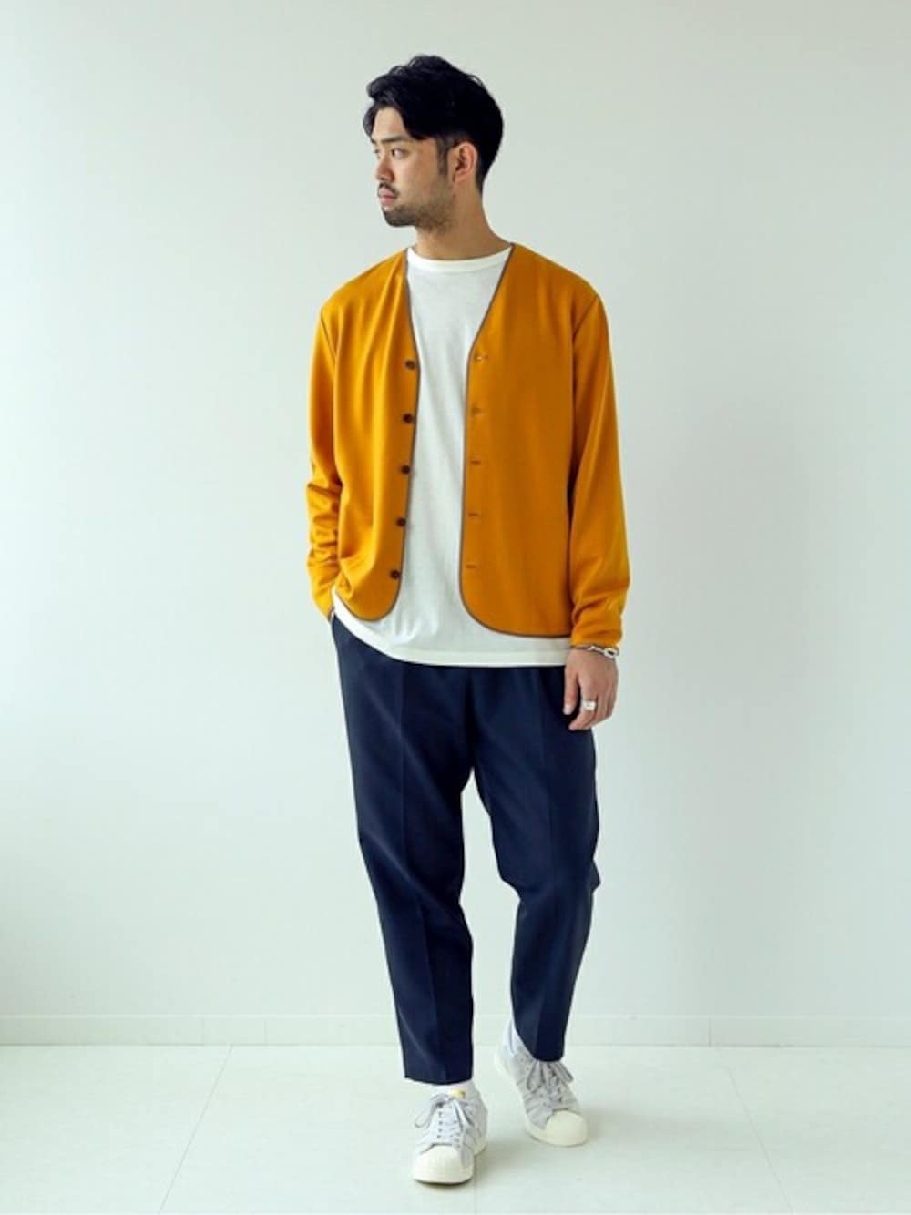 イエロー系のカーディガン/ボレロ、ホワイト系のTシャツ/カットソー、ブルー系のその他パンツを着用したメンズの秋コーディネートの1枚目の写真