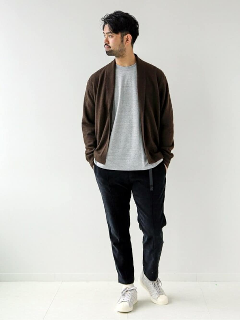 ブラウン系のニット/セーター、グレー系のTシャツ/カットソー、ブラック系のその他パンツを着用したメンズの秋コーディネートの1枚目の写真