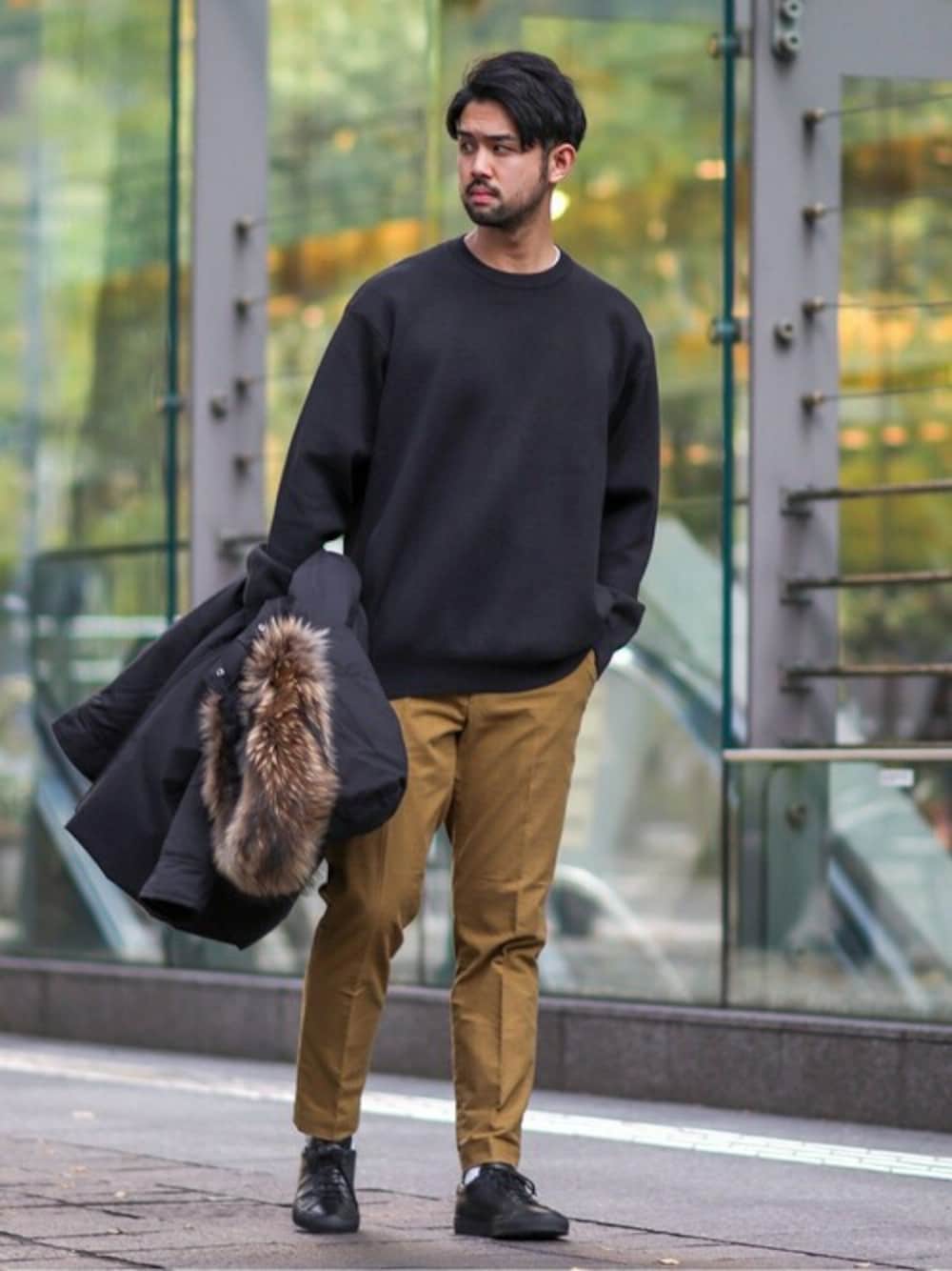 ブラック系のニット/セーター、ベージュ系のその他パンツ、ブラック系のダウンジャケット/コートを着用したメンズの冬コーディネートの1枚目の写真