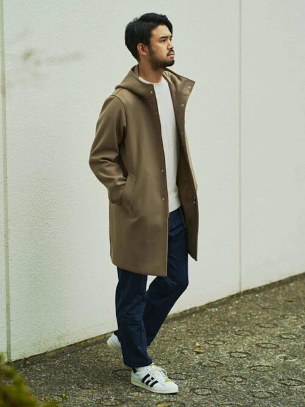 ベージュ系のその他アウター、ブルー系のその他パンツ、ホワイト系のスニーカーを着用したメンズの冬コーディネートの1枚目の写真