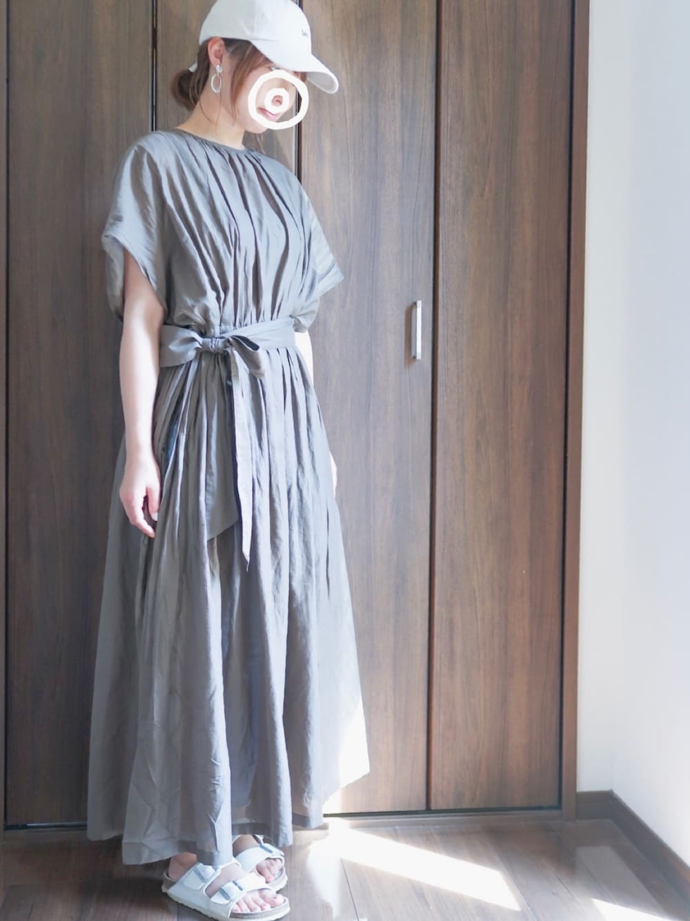 ホワイト系のサンダル、グリーン系のワンピース、ベージュ系のキャップを着用したレディースの夏コーディネートの1枚目の写真