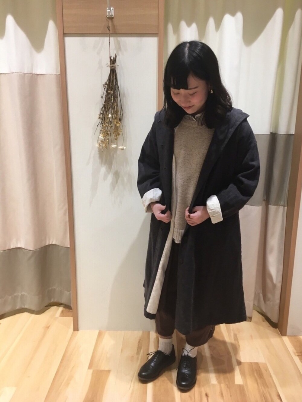 ブラック系のシャツ/ブラウス、ブラウン系のその他パンツ、ベージュ系のニット/セーターを着用したレディースの春コーディネートの1枚目の写真