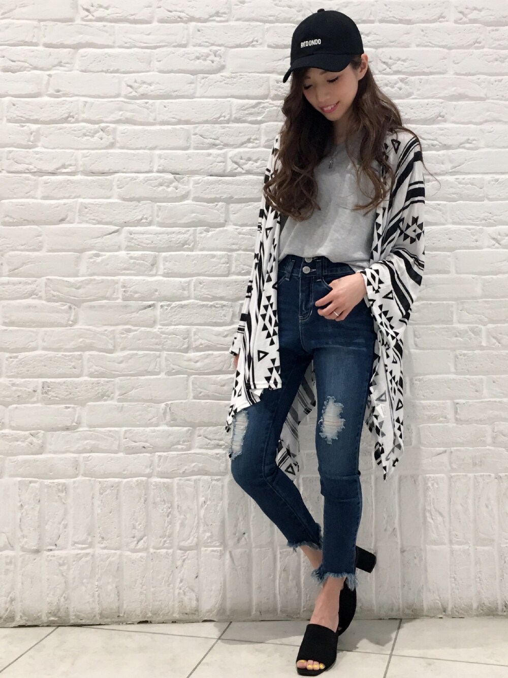 「春コーデ、カジュアル、キャップ、アンサンブル、カーディガン、ポンチョ、デニム、ハイウエスト、スキニーデニム、VENCE EXCHANGE」｜「VENCEEXCHANGEのLAビーチロゴキャップ （キャップ、ブラック系）」を使った、阪田 千鶴さん（レディース・157cm）の春コーディネートの1枚目の写真